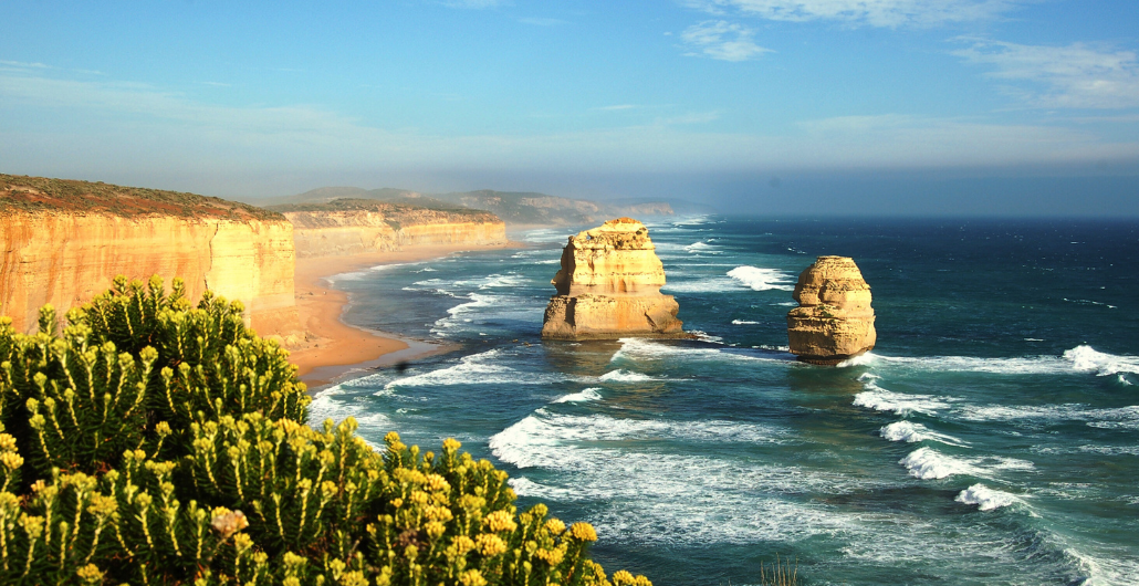 Scenic landscape showcasing the Twelve Apostles along the coastline, with the ocean's waves gently lapping at the shore.